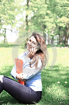 Young pretty girl working on laptop outdoor, lying on grass, caucasian 20 years old