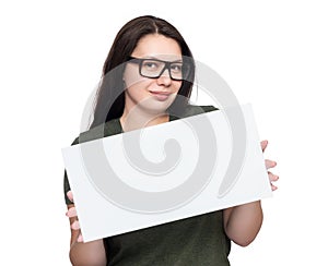 A young pretty happy girl with glasses holds a white blank poster in her hands, isolated on a white