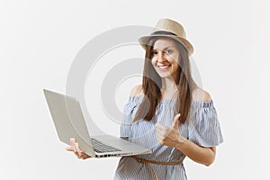 Young pretty happy woman in blue dress, hat working on modern laptop pc computer isolated on white background. People