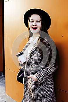 Young pretty hipster girl student with coffee cup posing adorable smiling, lifestyle people concept outdoor