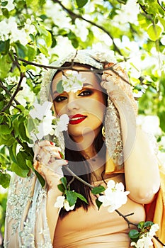 Young pretty indian girl in jewelry and veil posing cheerful happy smiling in green park, lifestyle people concept