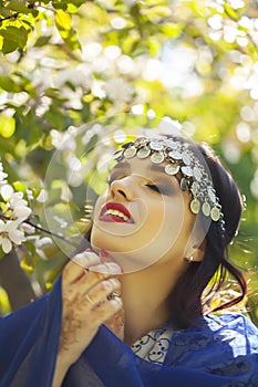 Young pretty indian girl in jewelry and veil posing cheerful happy smiling in green park, lifestyle people concept