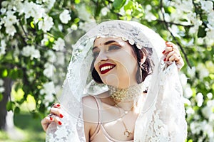 Young pretty indian girl in jewelry and veil posing cheerful happy smiling in green park, lifestyle people concept