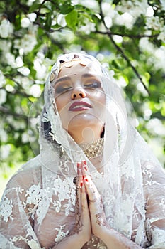 Young pretty indian girl in jewelry and veil posing cheerful happy smiling in green park, lifestyle people concept