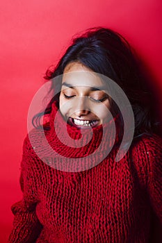 Young pretty indian mulatto girl in red sweater posing emotional