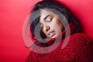 Young pretty indian mulatto girl in red sweater posing emotional