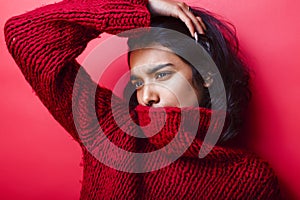 Young pretty indian mulatto girl in red sweater posing emotional