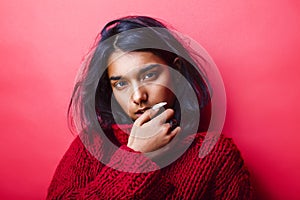 Young pretty indian mulatto girl in red sweater posing emotional