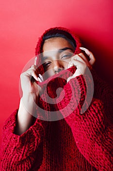 Young pretty indian mulatto girl in red sweater posing emotional