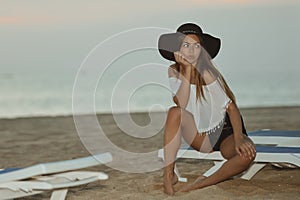 Young pretty lady on beach relaxing in the evening on summer outdoors background, vacation travel