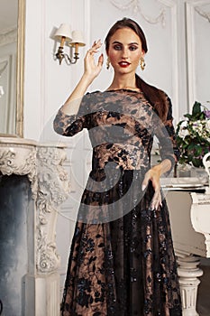 young pretty lady in black lace fashion style dress posing in rich interior of royal hotel room, luxury lifestyle people