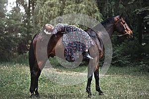 Young pretty latin girl laying on horseback in the forest. love animals concept. love horses