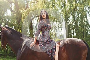 Young pretty latin girl laying on horseback in the forest. love animals concept. love horses