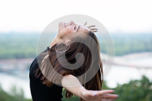 Young pretty likable cheerful woman posing summer city outdoor in Kyiv, Ukraine. Beautiful self-confident girl dressed in black