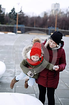 Young pretty mother hugging her cute little preschool daughter smiling