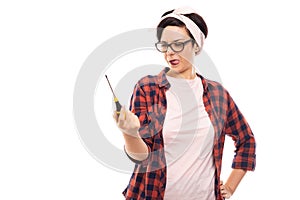 Young pretty pin-up girl looking at screwdriver
