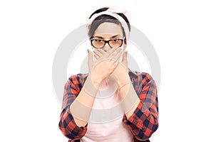 Young pretty pin-up girl wearing glasses and covering mouth gesture.