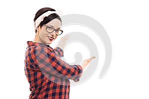 Young pretty pin-up girl wearing glasses showing copyspace