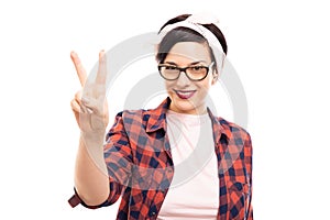 Young pretty pin-up girl wearing glasses showing victory gesture