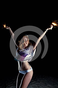 Young Pretty Red Haired Woman playing on a Beach at Night