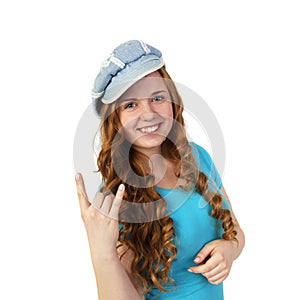 Young pretty redhead girl in cap shows heavy metal gesture