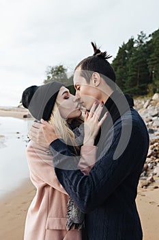 Young pretty sensual couple hugging and kissing at the beach.