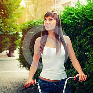 Young pretty sexy woman retro hipster style outdoor portrait with with red bicycle has fun and smiling