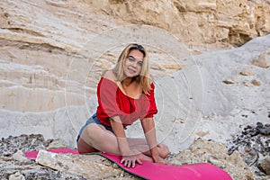 Young pretty slim woman doing workout relax yoga exercise at nature sand quarry