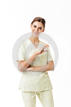 Young pretty smiling nurse in uniform holding syringe in hand happily looking in camera over white background isolated