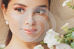 Young pretty smiling woman with flowers, perfect female face close up portrait