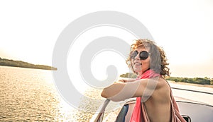 Young pretty solo woman traveler at sunset on boat trip
