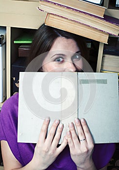 Young pretty student girl with a lot of books in library emotional, lifestyle people concept