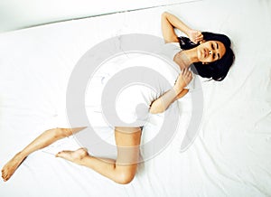 Young pretty tann woman in bed among white sheets having fun, tr