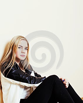 Young pretty teenage blond girl sitting on floor at home despair