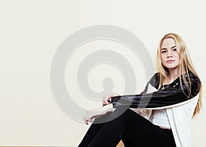 Young pretty teenage blond girl sitting on floor at home despair