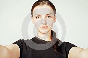 Young pretty teenage girl making selfie isolated on white background close up