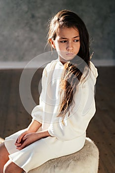 Young pretty teenage girl with sad emotions looking down. Close up portrait