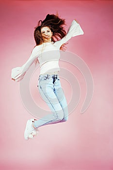 Young pretty teenage redhair girl jumping cheerful isolated on pink background, lifestyle people concept