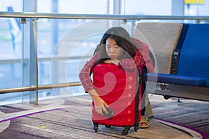 Young pretty tired and exhausted Asian Korean tourist woman in airport sleeping bored sitting at boarding gate hall waiting for de