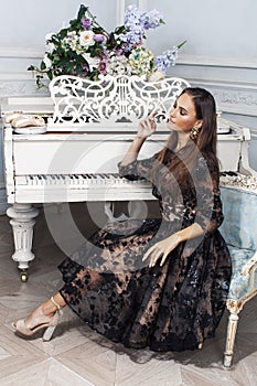 young pretty woman in black lace fashion style dress posing in rich interior of royal hotel room, luxury lifestyle