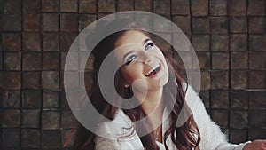 Young pretty woman brunette looking to the camera and histrionic laughing