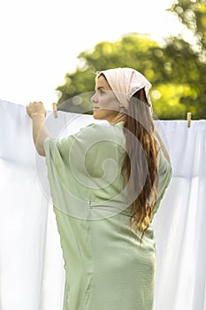 Young pretty white woman hanging up laundry on