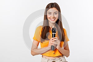 Young pretty woman happy and motivated, singing a song with a microphone, presenting an event or having a party, enjoy