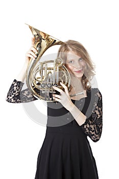 Young pretty woman holding french horn