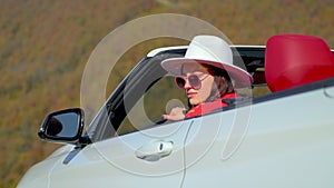 young pretty woman inside convertible car, lady enjoying weekend trip in countryside, portrait