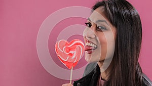 Young pretty woman licks a big lollipop