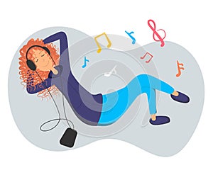 Young pretty woman lies on the floor and listens music tunes by big headphones. Girl looks joyful relaxed and happy