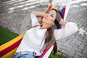 Young pretty woman lying in a hammock in garden
