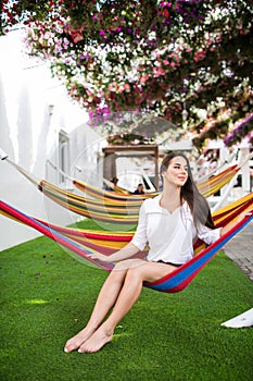 Young pretty woman lying in a hammock in garden