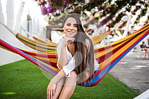 Young pretty woman lying in a hammock in garden